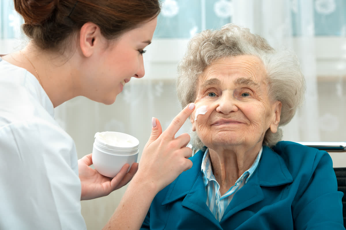 Pflegekraft kümmert sich einfühlsam um Parkinson-Patientin